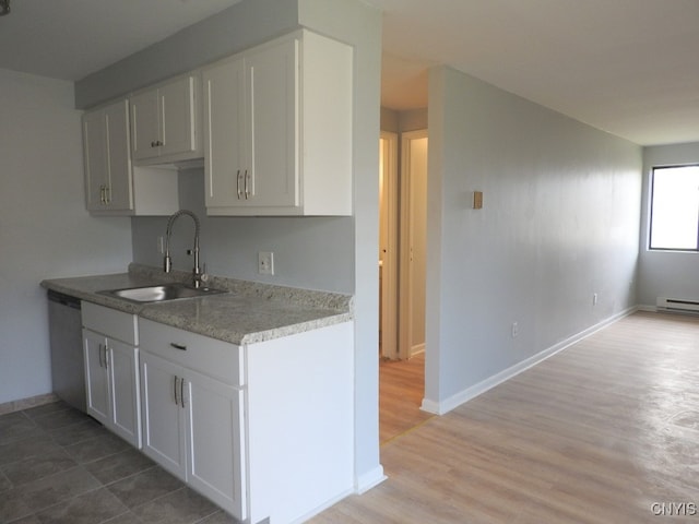 kitchen with stainless steel dishwasher, light wood-type flooring, sink, and baseboard heating