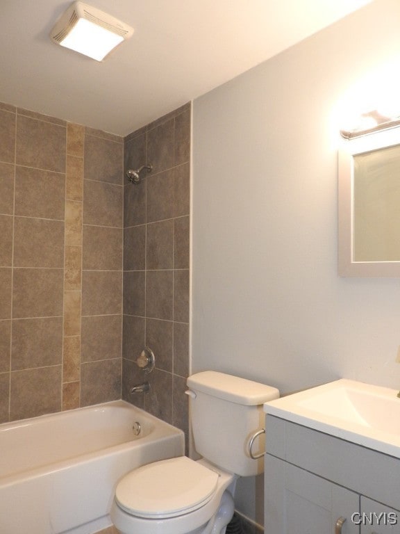 full bathroom with vanity, tiled shower / bath combo, and toilet