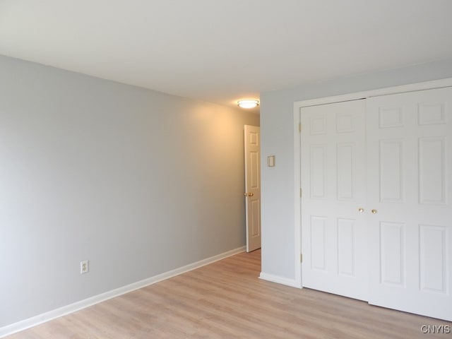 unfurnished bedroom featuring light hardwood / wood-style floors and a closet