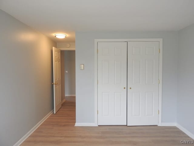 unfurnished bedroom featuring light hardwood / wood-style flooring and a closet