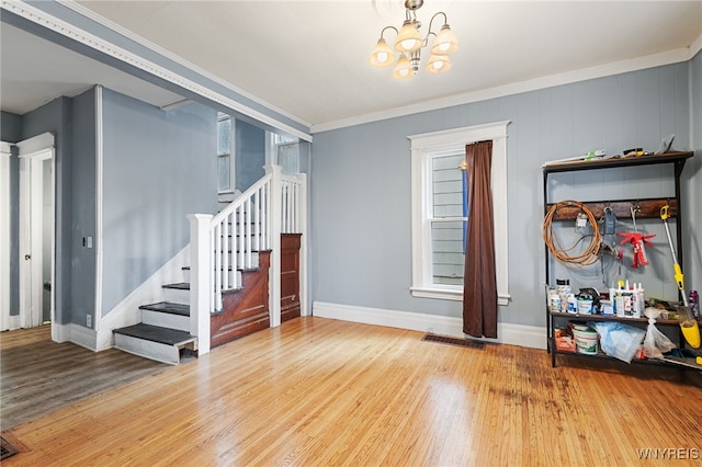 foyer with hardwood / wood-style flooring, crown molding, and a healthy amount of sunlight