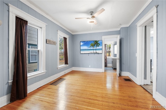 unfurnished room featuring light hardwood / wood-style flooring, plenty of natural light, and ornamental molding