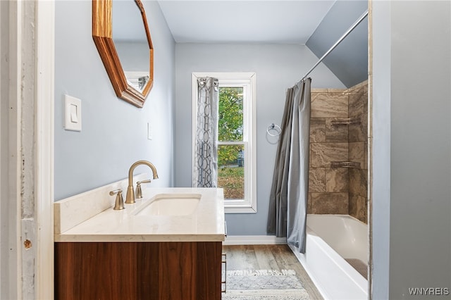 bathroom featuring vanity, hardwood / wood-style flooring, vaulted ceiling, and shower / bath combo with shower curtain