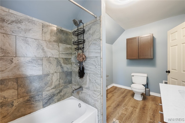 full bathroom with hardwood / wood-style floors, lofted ceiling, toilet, vanity, and tiled shower / bath