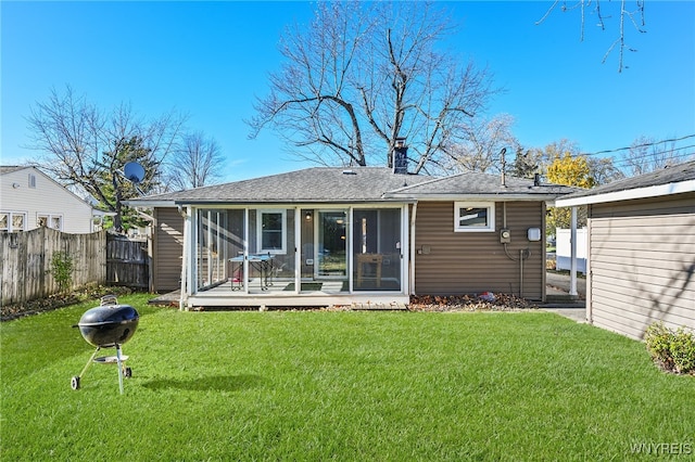 rear view of property with a yard and a sunroom