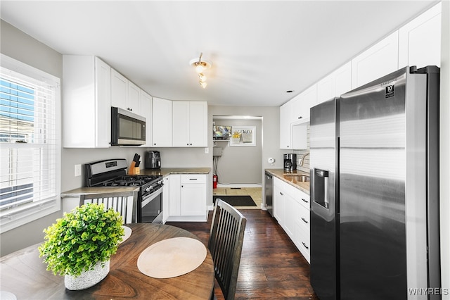 kitchen featuring white cabinetry, sink, dark hardwood / wood-style floors, and appliances with stainless steel finishes