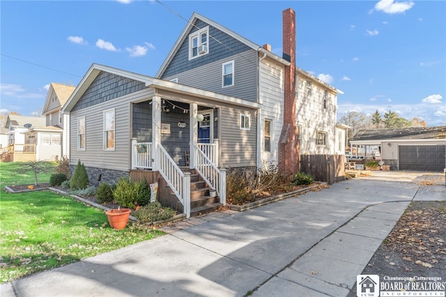 view of front of property featuring a front yard, covered porch, and a chimney