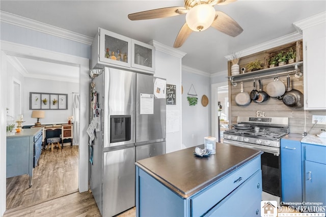 kitchen featuring blue cabinets, a center island, appliances with stainless steel finishes, crown molding, and light wood finished floors