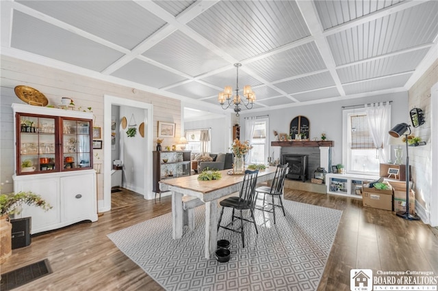 dining room with visible vents, coffered ceiling, and wood finished floors