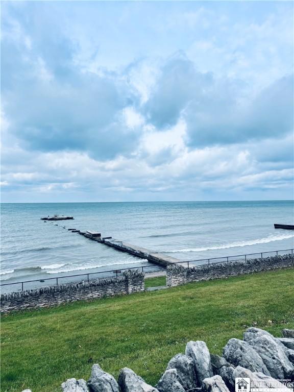 view of water feature with a view of the beach and fence