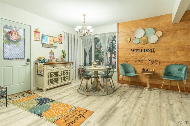 dining area featuring a chandelier, hardwood / wood-style flooring, and wood walls