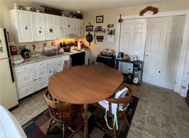 kitchen featuring white cabinets, a textured ceiling, white appliances, and sink