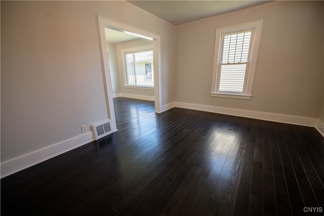 unfurnished room with plenty of natural light and dark wood-type flooring