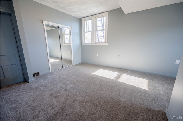 unfurnished bedroom with carpet flooring and a closet