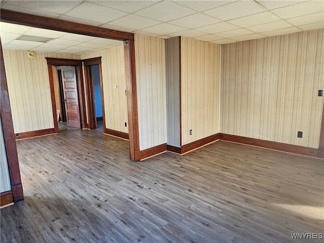 unfurnished room with dark hardwood / wood-style flooring and a paneled ceiling