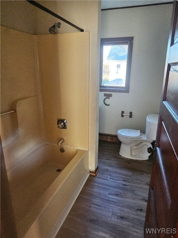 bathroom with bathtub / shower combination, hardwood / wood-style floors, and toilet