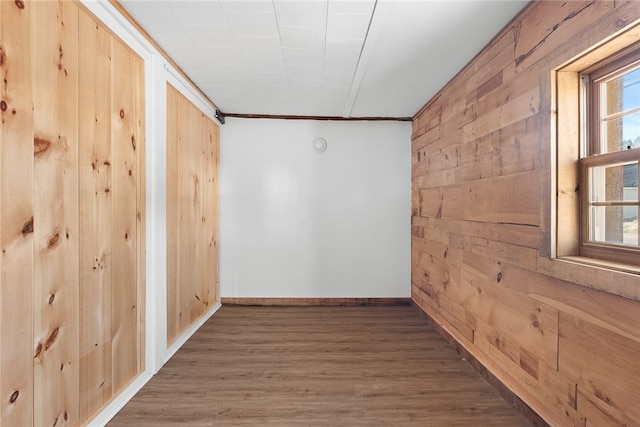 hall featuring wood walls, ornamental molding, and dark wood-type flooring