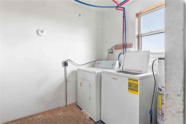 clothes washing area with washer and dryer and gas water heater