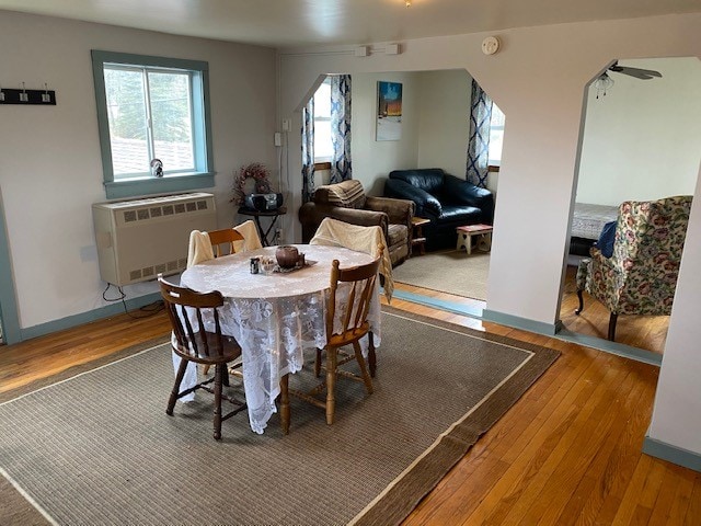 dining room with heating unit, ceiling fan, and hardwood / wood-style floors