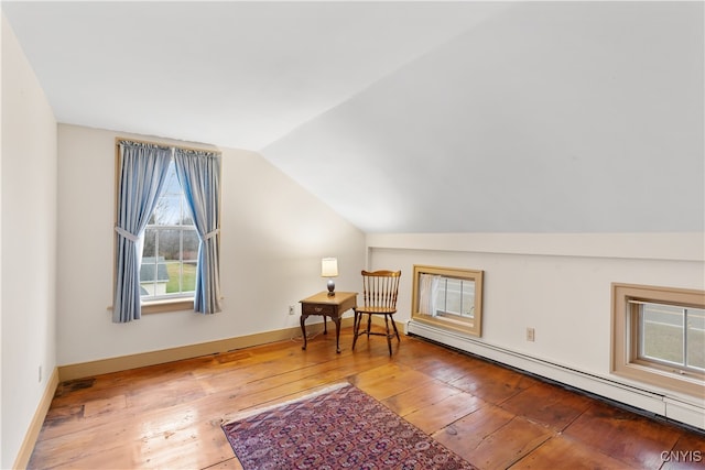 interior space with hardwood / wood-style floors, lofted ceiling, and a baseboard radiator