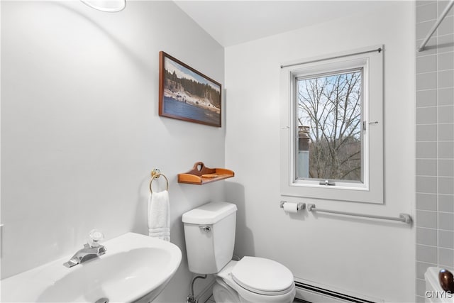 bathroom featuring toilet, a baseboard heating unit, and sink