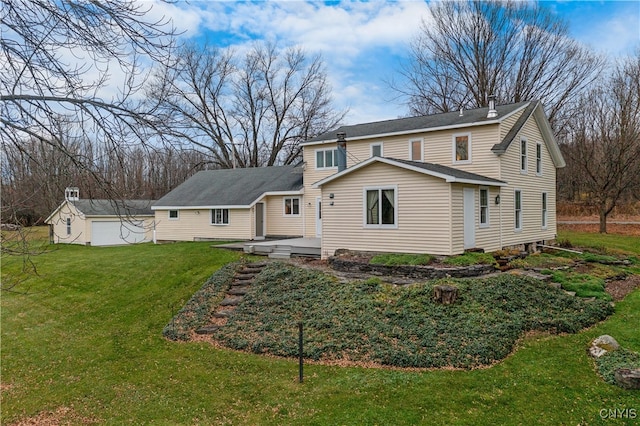 rear view of house with a lawn and an outdoor structure