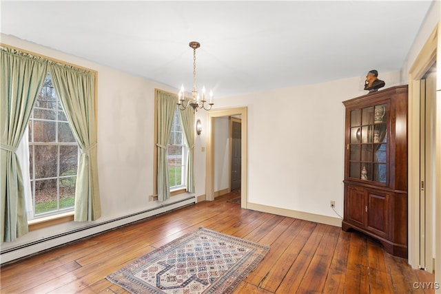 unfurnished dining area featuring plenty of natural light, dark hardwood / wood-style flooring, and baseboard heating