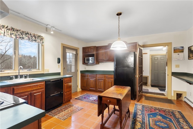 kitchen featuring pendant lighting, sink, light tile patterned floors, and black appliances