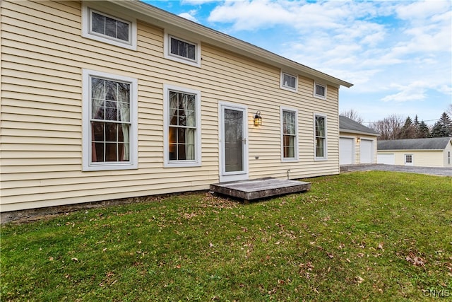 rear view of house featuring a yard and a garage