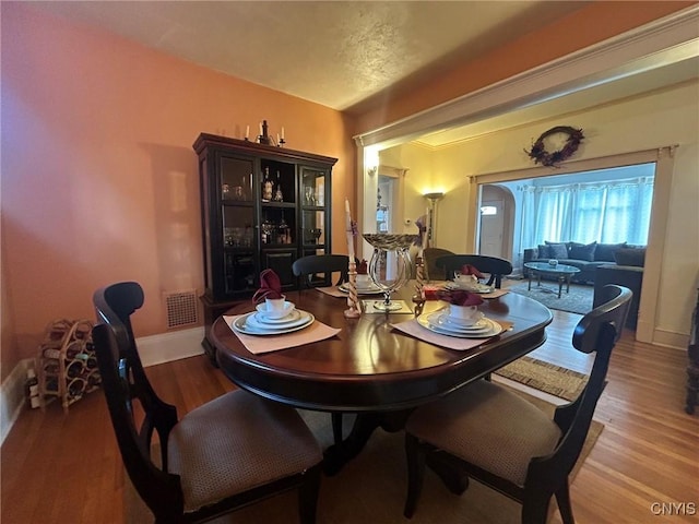 dining space with wood-type flooring