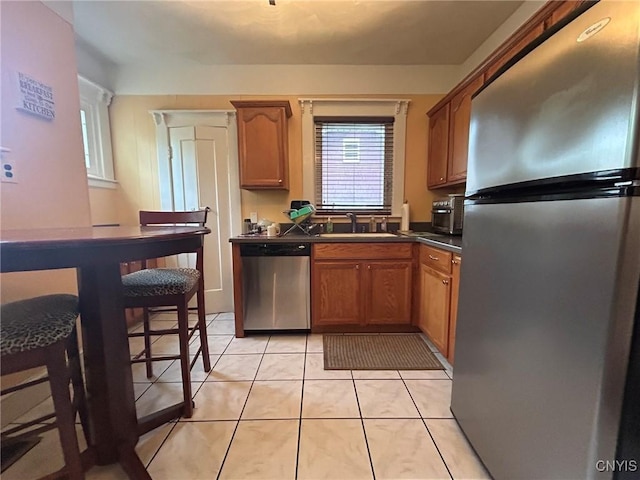 kitchen featuring sink, light tile patterned floors, and stainless steel appliances