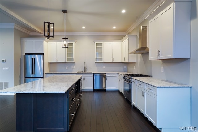 kitchen with hanging light fixtures, wall chimney exhaust hood, dark hardwood / wood-style flooring, white cabinetry, and stainless steel appliances