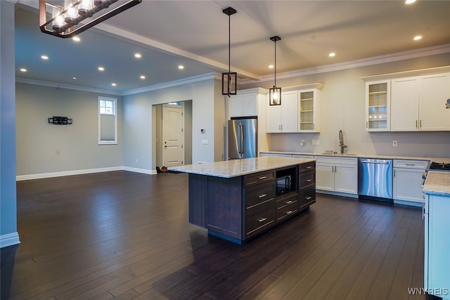 kitchen with a center island, dark wood-type flooring, decorative light fixtures, white cabinetry, and stainless steel appliances