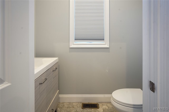 bathroom with tile patterned flooring, vanity, and toilet