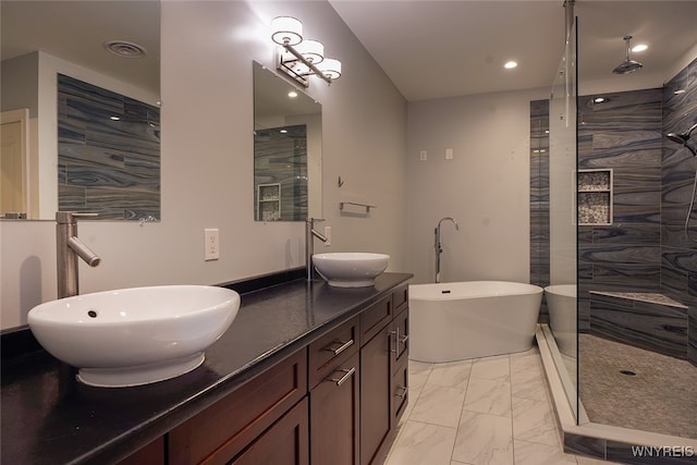 bathroom with vanity and shower with separate bathtub