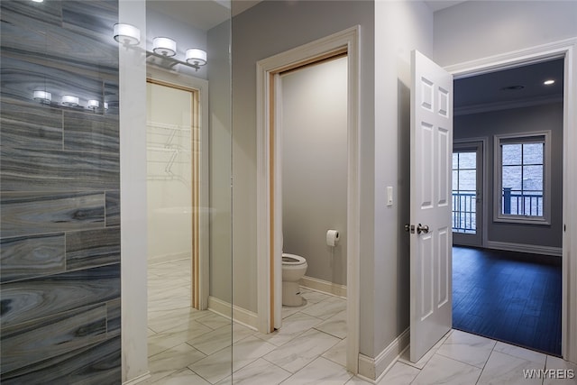 bathroom featuring walk in shower, crown molding, hardwood / wood-style floors, and toilet