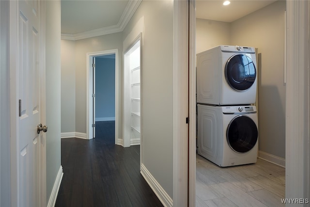 laundry area with hardwood / wood-style floors, stacked washer and dryer, and ornamental molding