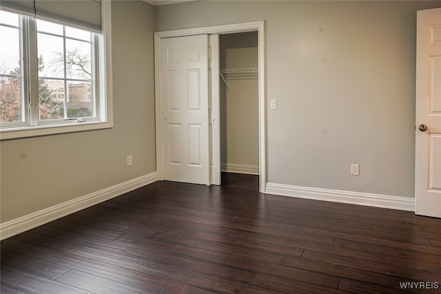 unfurnished bedroom featuring dark hardwood / wood-style floors and a closet