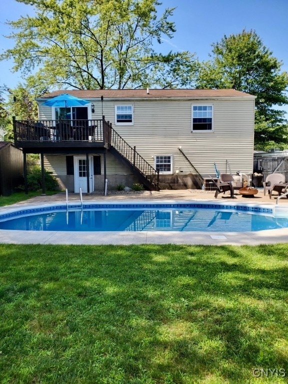 view of swimming pool featuring a lawn and a deck