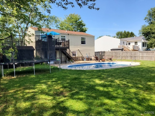 exterior space with a swimming pool side deck, a trampoline, and a lawn