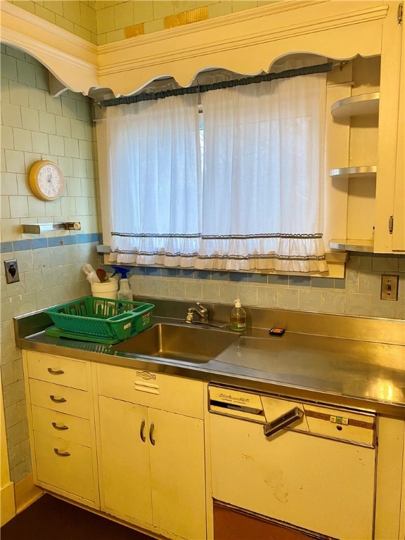 kitchen featuring tasteful backsplash, stainless steel counters, and sink