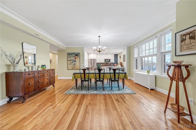 dining room with crown molding, light hardwood / wood-style flooring, and a notable chandelier