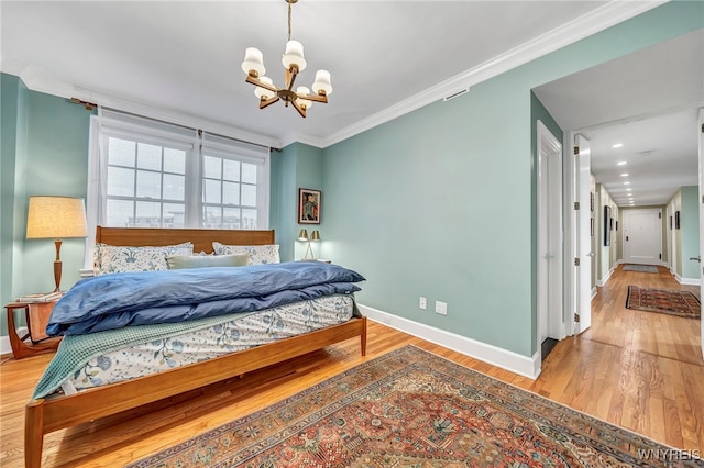 bedroom featuring crown molding, light hardwood / wood-style flooring, and a chandelier