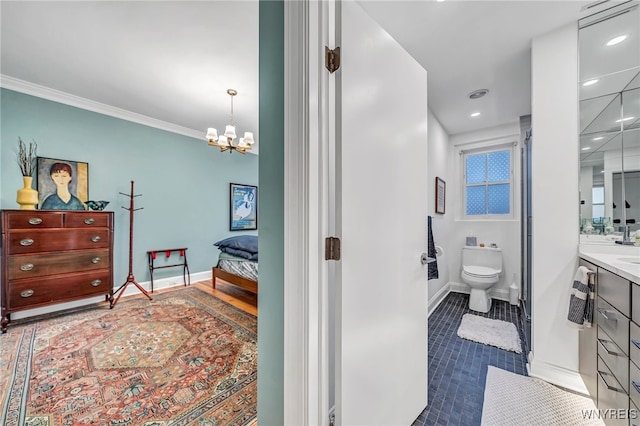 bathroom with vanity, an inviting chandelier, toilet, and ornamental molding