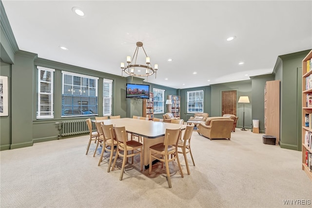 dining room with a notable chandelier, light colored carpet, ornamental molding, and radiator