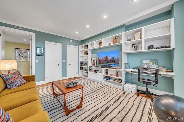 living room with built in desk, light hardwood / wood-style flooring, and crown molding