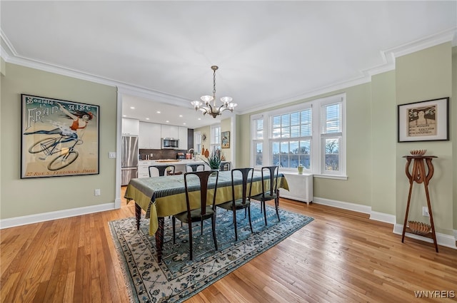 dining space featuring ornamental molding, light hardwood / wood-style floors, and an inviting chandelier