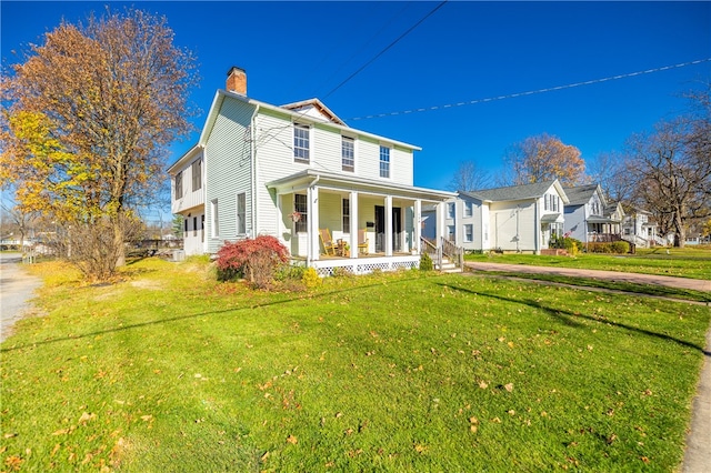 view of front facade with a front lawn and covered porch