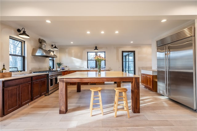 kitchen featuring a kitchen breakfast bar, high quality appliances, and extractor fan