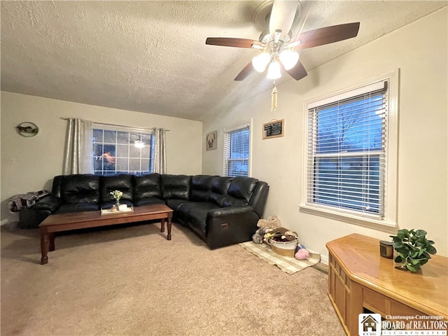 living room featuring ceiling fan, light colored carpet, and a textured ceiling